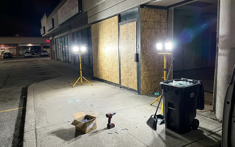 Two storefront openings boarded with OSB at a Scarborough plaza at 1am