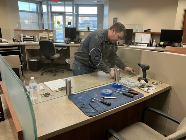 Bank teller divider glass reset on stainless standoff pins
