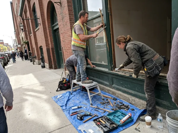 Crew removing a loose glazing stop at a St. Lawrence Market shop
