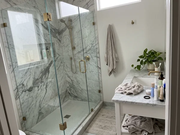 Starphire frameless shower with brass hinges in Forest Hill
