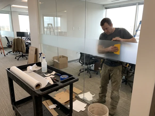 Installer applying matching frosted privacy film to a new partition panel